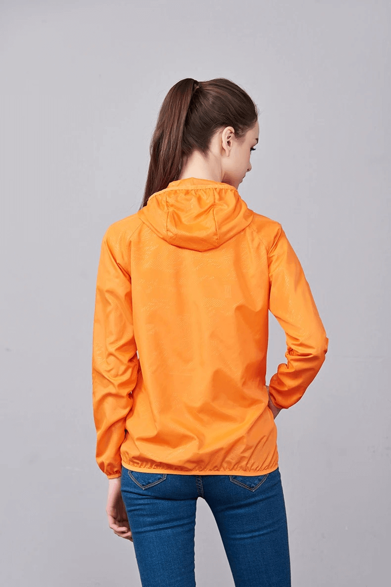 Woman wearing orange waterproof polyester jacket, perfect for hiking and outdoor adventures with sun protection and anti-UV features.